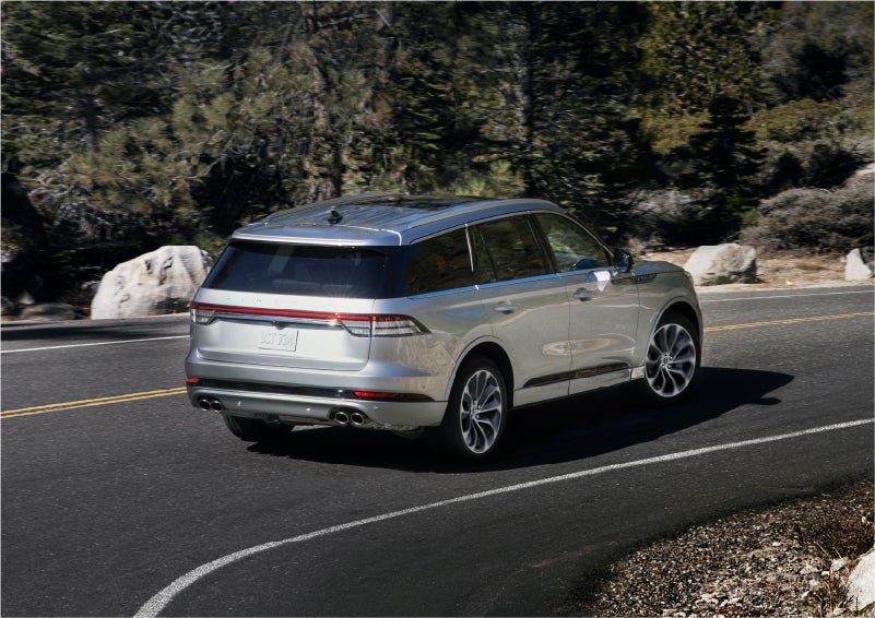A 2023 Lincoln Aviator® Grand Touring model is shown being driven on a tight turn of a mountain road | Empire Lincoln in Abingdon VA